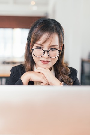 Close up Asian young business freelance woman working online business with laptop in cafe shop. Working concept, in selective focus.の写真素材