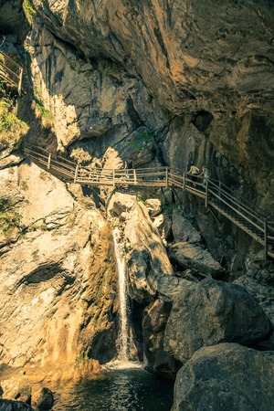 Austria tourist attraction styria waterfalls BÃ¤renschÃ¼tzklamm three people walk on a bridge above waterfallの写真素材