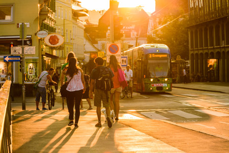 Austria, Styria, Graz, street tram people walk on side walk on a bridge busy tourist spotのeditorial素材