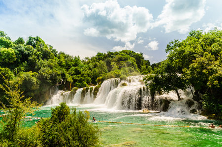 Waterfalls of Krka National Park, Dalmatia / Croatia - 21 July 2014: Tourists swimming near waterfalls in crystal clear water. Tourist spot in Dalmatia Krka National Park, place to go and visitのeditorial素材