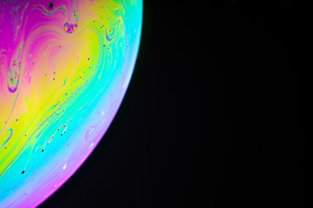 Rainbow soap bubble on a dark background. Close-up of a bubbleの写真素材