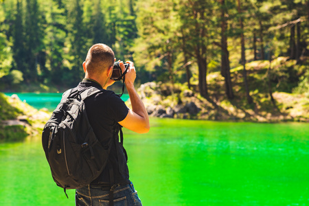 Hiker with camera at green lake in styria Austria. Copy spaceの写真素材