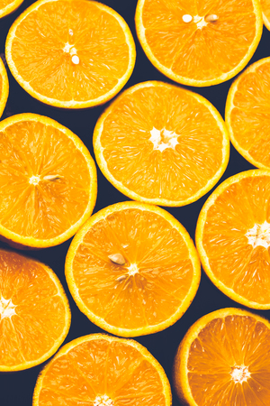 Orange background. Closeup of half cut fruits in pattern next to each otherの写真素材