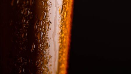 Glass of beer with foam on black background closeup. copy space on rightの写真素材