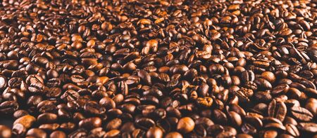 Coffee beans background. Beans spreed over table. Coffee concept