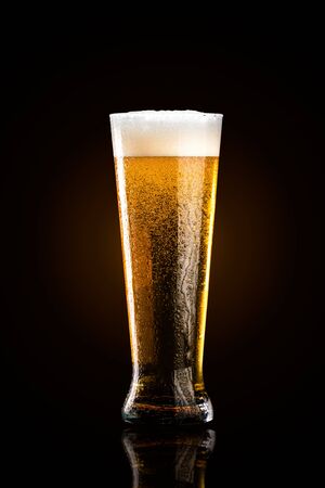 Glass of cold golden beer isolated on a black backgroundの写真素材