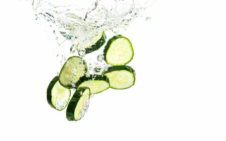Sliced cucumber splashing water isolated on white background. Skin moisturizing cosmetics conceptの写真素材