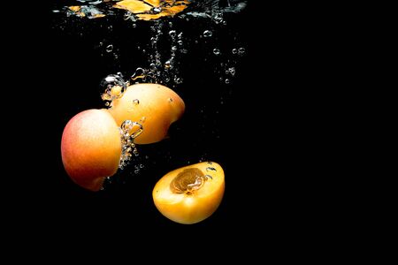 Fresh Nectarine with water splash isolated over black background. Health conceptの写真素材