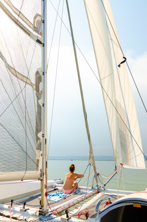 Podersdorf am see, Austria - August 15 2015: Girl on a catamaran boat sailing through neusiedler...