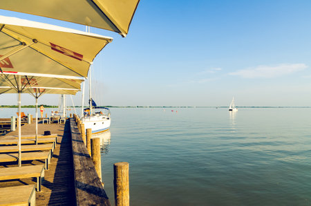 Podersdorf am see, Austria - July 17 2015: Neusiedler lake port harbor with bars and restaurant. People docking their boats.のeditorial素材
