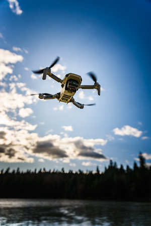 Graz, Austria - December 29 2019. DJI Mavic Mini drone flying in the countryside above frozen lake on sunny winter dayのeditorial素材