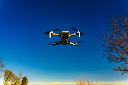 Graz, Austria: 02.01.2020 - Close up shoot of a DJI Quadcopter Drone Mavic mini 249g. Drone flying against blue sky background.のeditorial素材