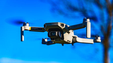 Graz, Austria: 02.01.2020 - Close up shoot of a DJI Quadcopter Drone Mavic mini 249g. Drone flying against blue sky background.のeditorial素材