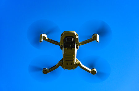 Graz, Austria: 02.01.2020 - Close up shoot of a DJI Quadcopter Drone Mavic mini 249g. Drone flying against blue sky background.のeditorial素材