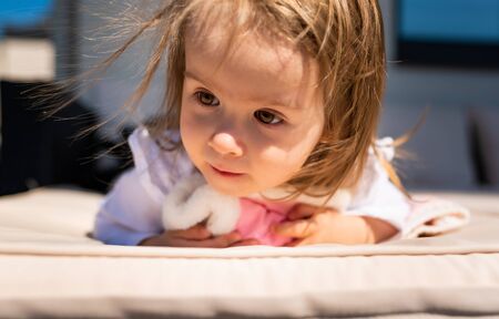 Portrait of 2 year old sweet girl outside, sunny spring day in backyard. Child backgroundの写真素材