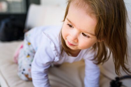 Portrait of 2 year old sweet girl outside, sunny spring day in backyard. Child backgroundの写真素材