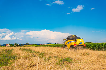 Premstatten, Austria - 21.07.2020: Combine harvester going through wheat field in rural areaのeditorial素材