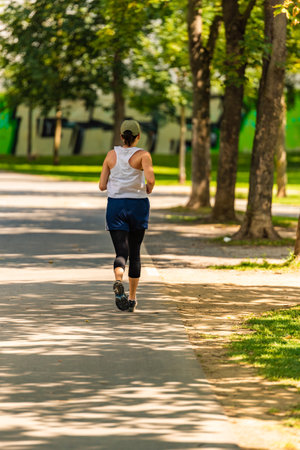 Graz, Styria,Austria - 24.06.2020: View at young woman jogging along path in parkのeditorial素材