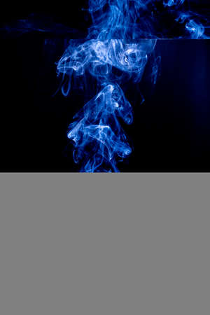 Blue abstract shaped smoke against black background. Abstract backgroundの写真素材