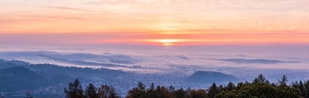 Panorama of Graz city covered if fog on autumn morning during sunraise. View from Plaubutsch hill...