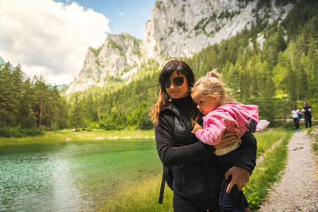 Young mother holding child on a walk around Gruner see, Green lake in Styria, Austriaの写真素材