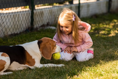 Child playing with dog on grass.の写真素材