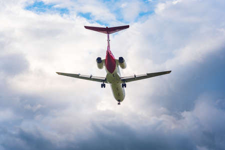 Passenger airplane landing against cloudy skyの写真素材