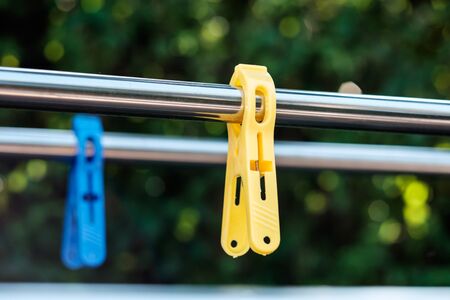 Yellow standalone cloth peg attached with stainless steel clothesline