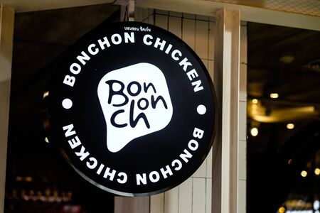 Bangkok, Thailand - December 12, 2019: Close-up glowing Bonchon chicken circular signboard ar MBK...