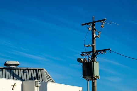 A high voltage electric pole installed with a transformer and connected to transmission line near the San Remo beachの写真素材
