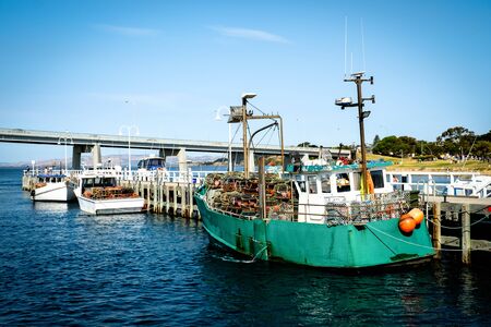 The fishing yachts parking at the dock yard near the San Remo beach and Phillip Island with a bridge...