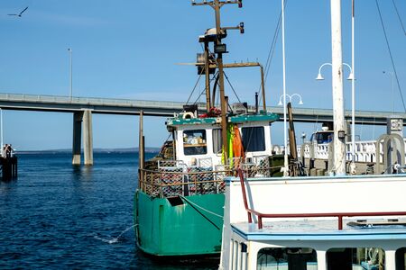 The fishing yachts parking at the dock yard near the San Remo beach and Phillip Island with a bridge...