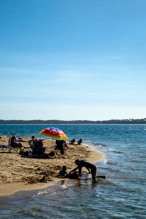 Groups of family with their kids playing sand and seawater at San Remo beach during holiday or weekendのeditorial素材