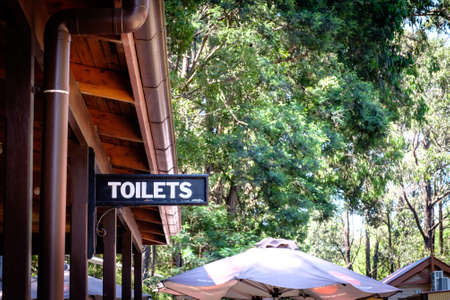 Melbourne, Australia - January 02, 2020: A metal toilet directional sign attached to a wooden pole at the train station in Melbourne, Australiaのeditorial素材