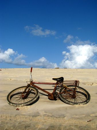 Abandoned bicycle in the sand dunes of Praia de Pipa beach, north-eastern Brazil.の写真素材