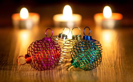 christmas balls of colored metal wire and lighted candlesの写真素材