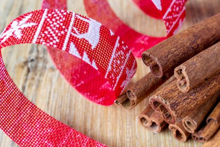 cinnamon and red Christmas ribbon on wooden backgroundの写真素材