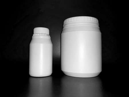 Empty plastic white bottles on a dark background.の写真素材