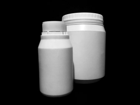 Empty plastic white bottles on a dark background.の写真素材