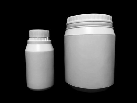 Empty plastic white bottles on a dark background.の写真素材