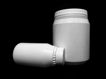 Empty plastic white bottles on a dark background.の写真素材