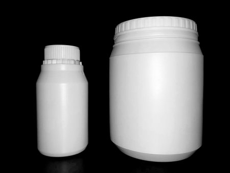 Empty plastic white bottles on a dark background.の写真素材