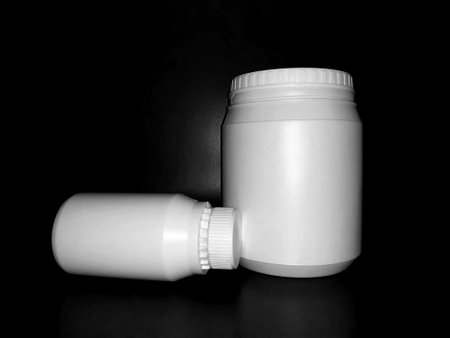 Empty plastic white bottles on a dark background.の写真素材
