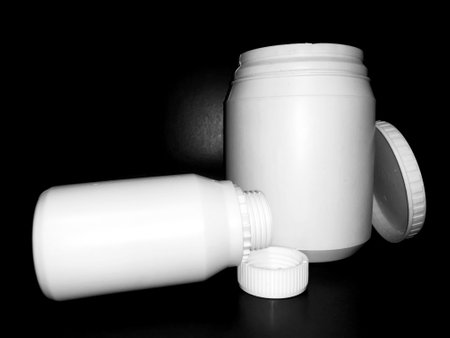 Empty plastic white bottles on a dark background.の写真素材