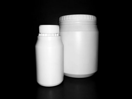Empty plastic white bottles on a dark background.の写真素材