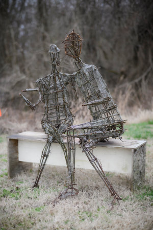 Rusty metal outdoor sculpture of lovers on a bench in Bell Buckle, Tennesseeの写真素材