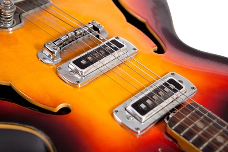Old electric guitar on white background, close up view
