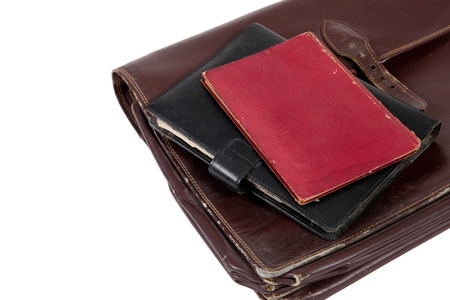 Books on top of old briefcase on a white background