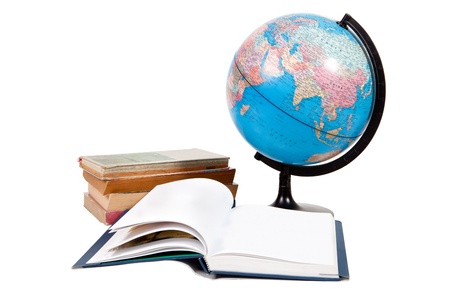 Stack of books and globe with one book open on white backgroundの写真素材