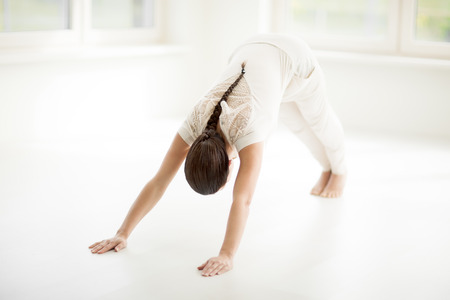 Young Caucasian woman doing yoga in sunny room.の写真素材